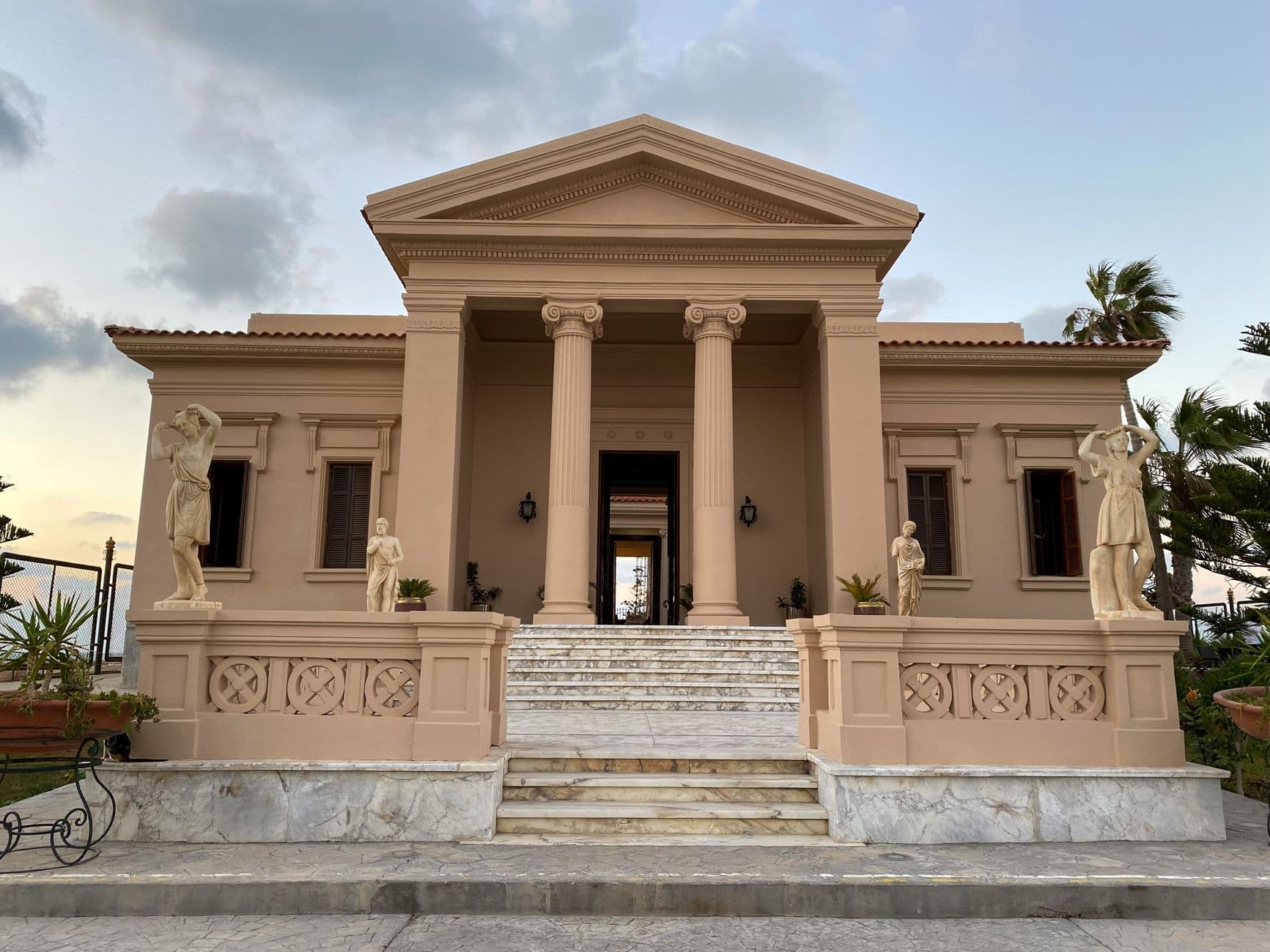 Elegant neoclassical building facade with statues in Alexandria, Egypt.