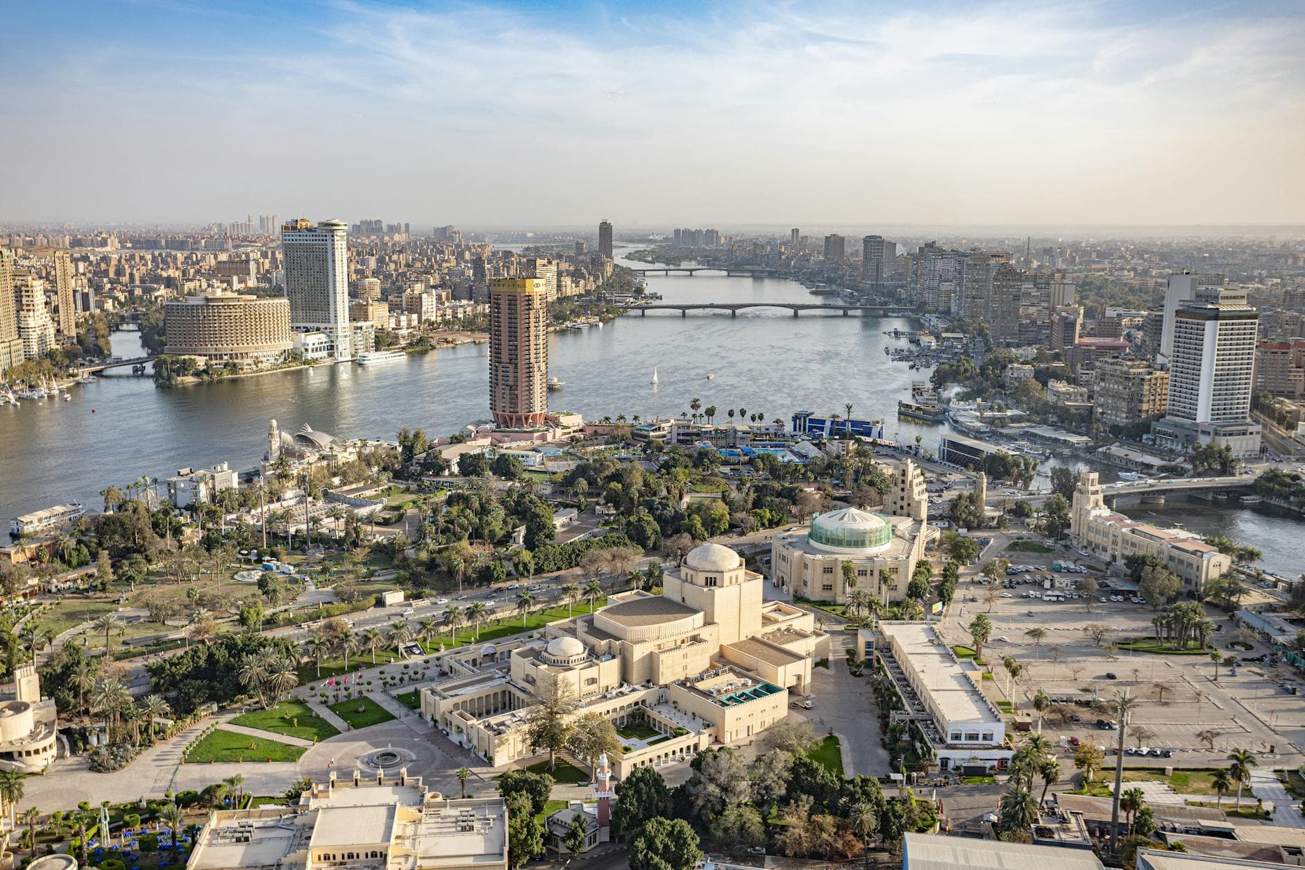 Stunning aerial panorama of Cairo, featuring the Nile River and iconic cityscape landmarks in vibrant daylight.