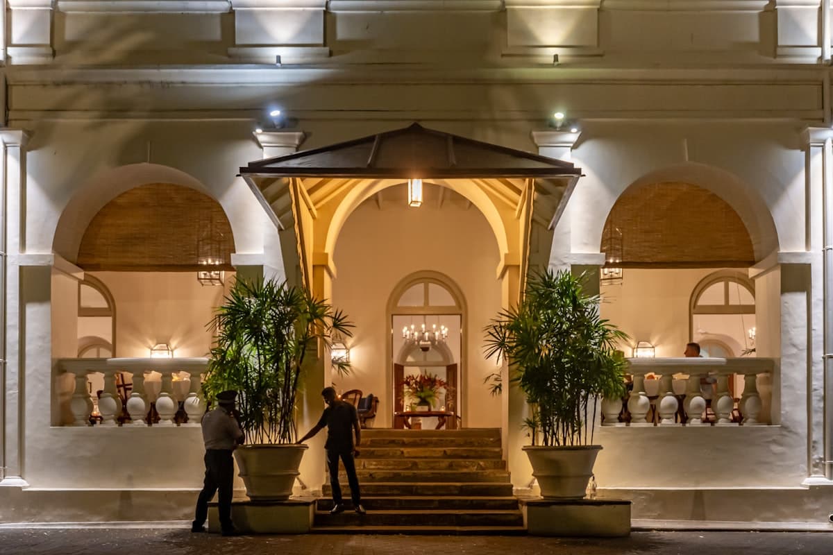 Elegant building entrance at night with two people.