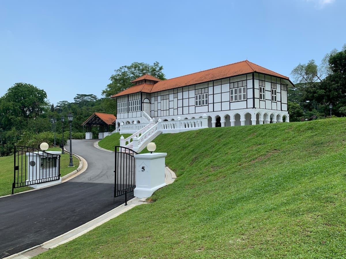 a large white building with a red roof on top of a hill