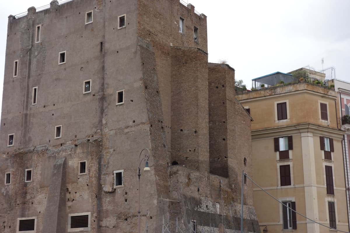 Ancient stone tower next to a modern building.