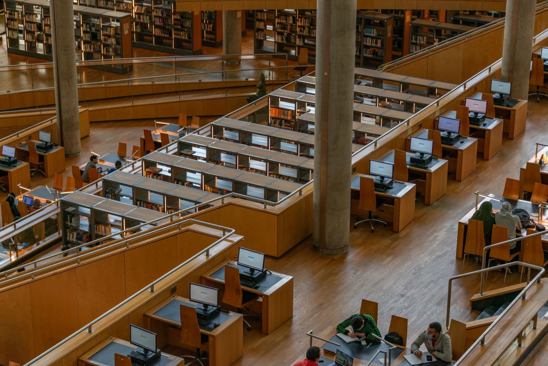 Spacious interior view of Bibliotheca Alexandrina showcasing wooden study areas and computers.