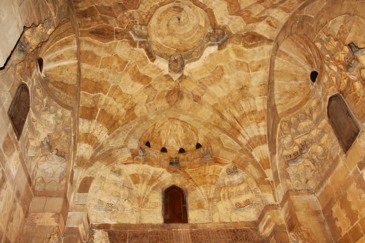 Ornate stone ceiling with arched alcoves and windows.
