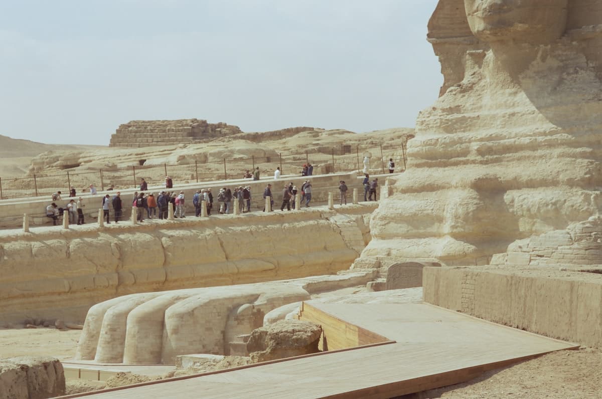 Tourists on promenade by great sphinx paws, giza.