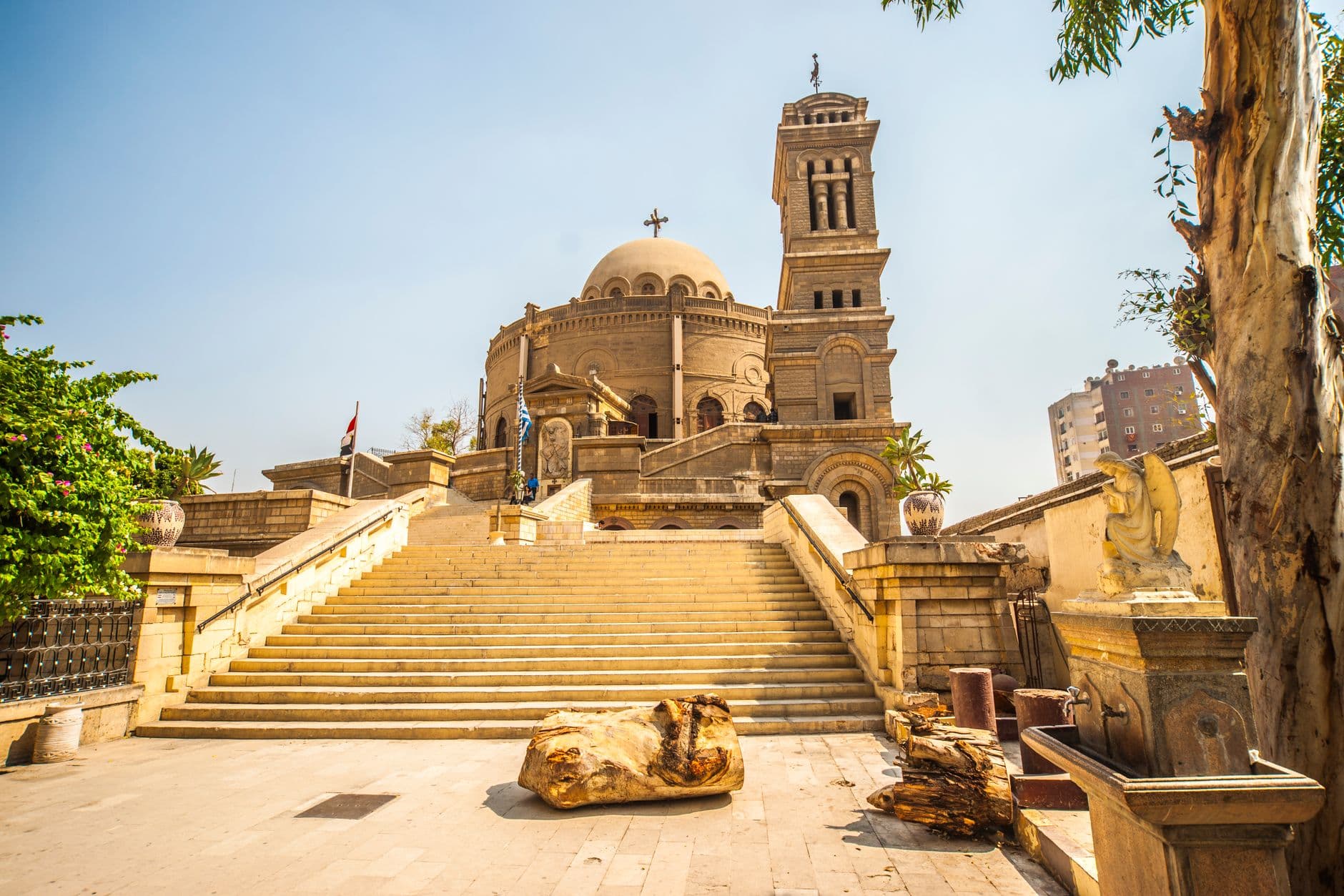 Exterior view of the historic St. George's Church in Cairo, showcasing its iconic tower and grand entrance stairs.