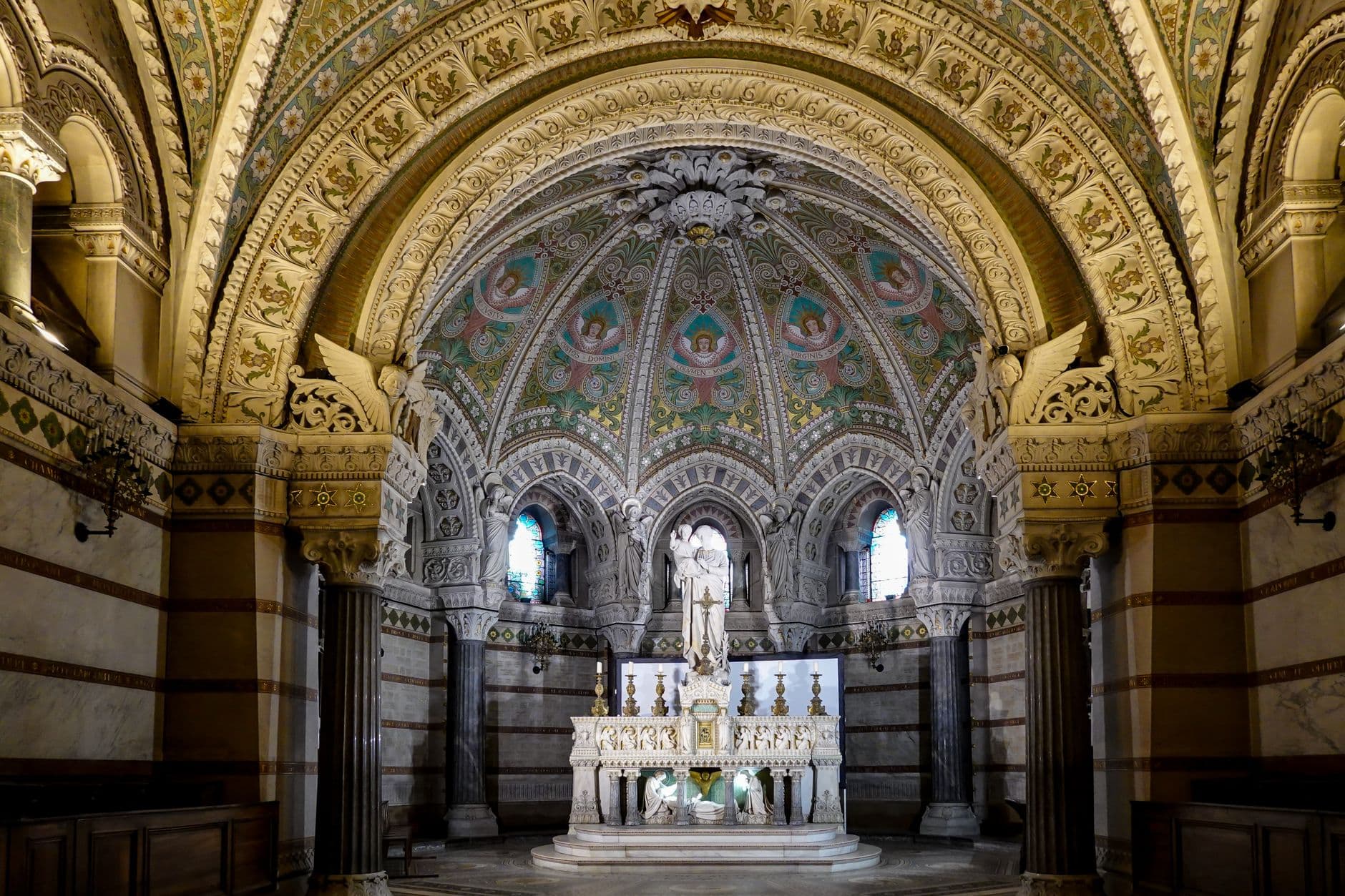 Intricate church interior showcasing beautifully decorated apse and altar.