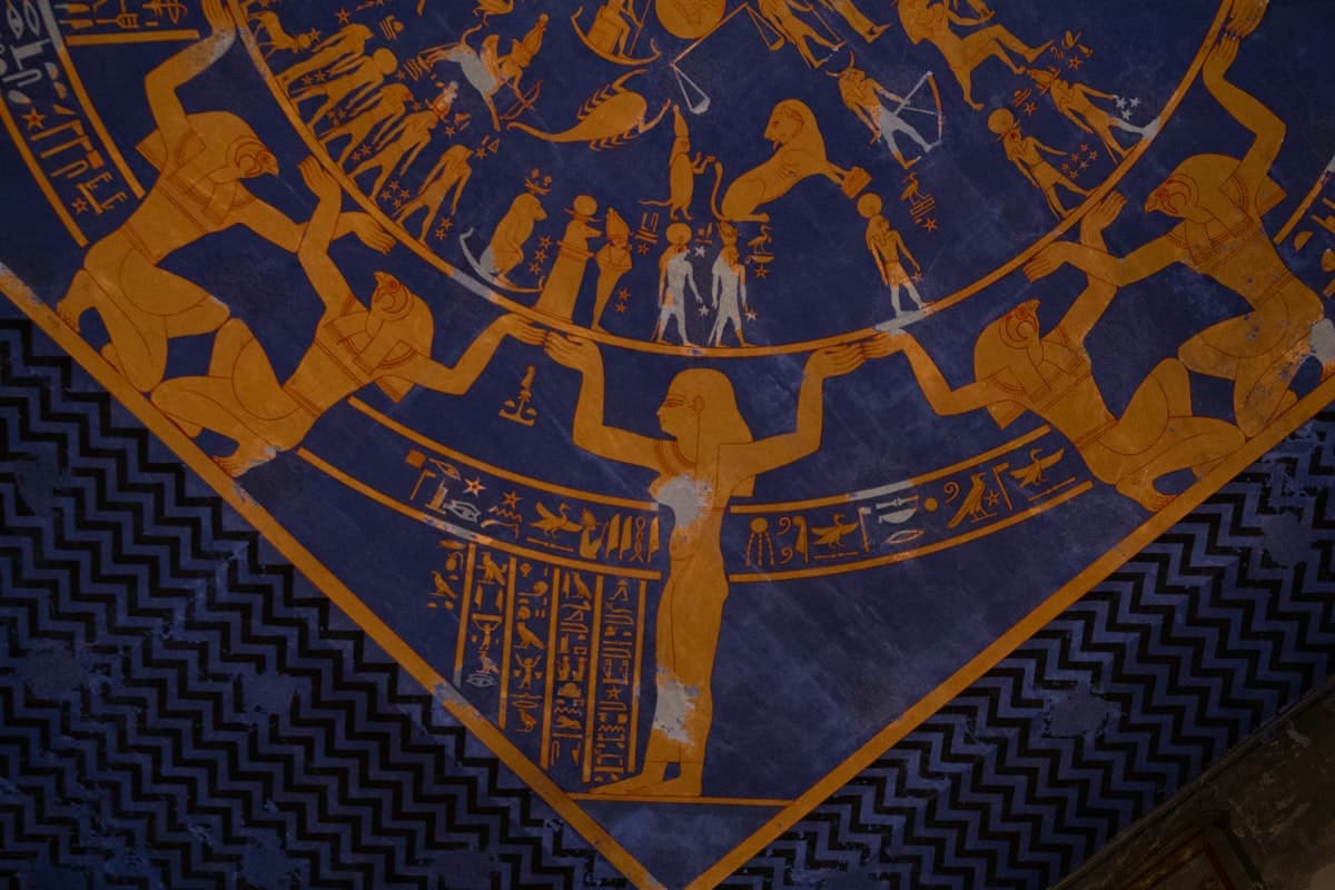 Ancient egyptian hieroglyphs and figures on a blue background