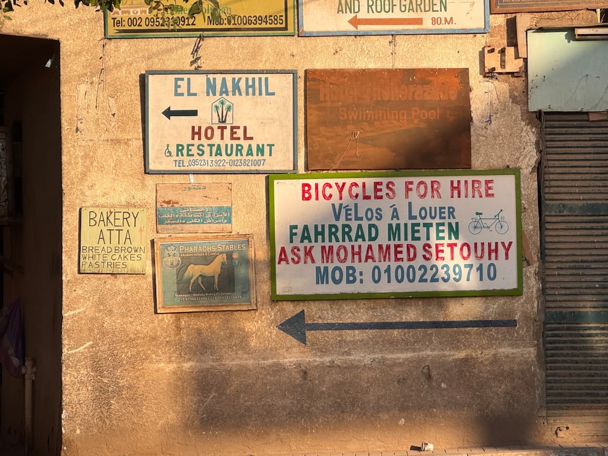 Signs for hotel, bakery, and bicycle rentals on wall.