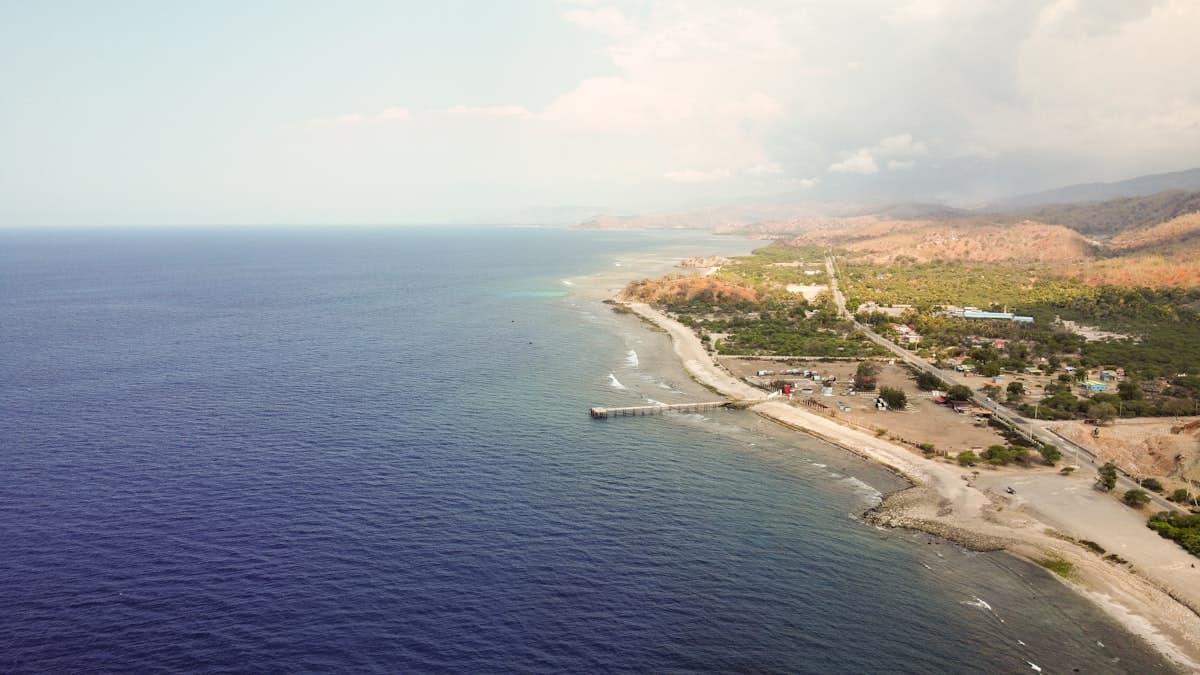 A large body of water next to a lush green hillside