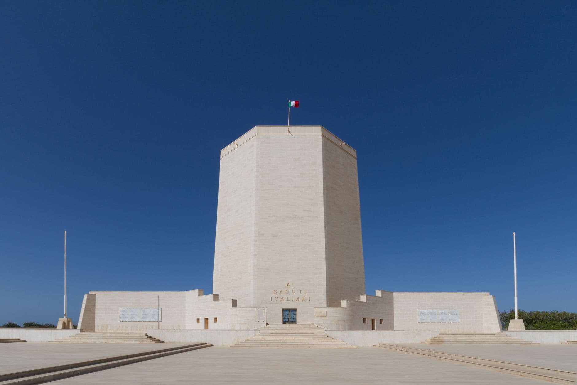 A majestic memorial tower in Italy with clear blue skies, symbolizing peace and remembrance.