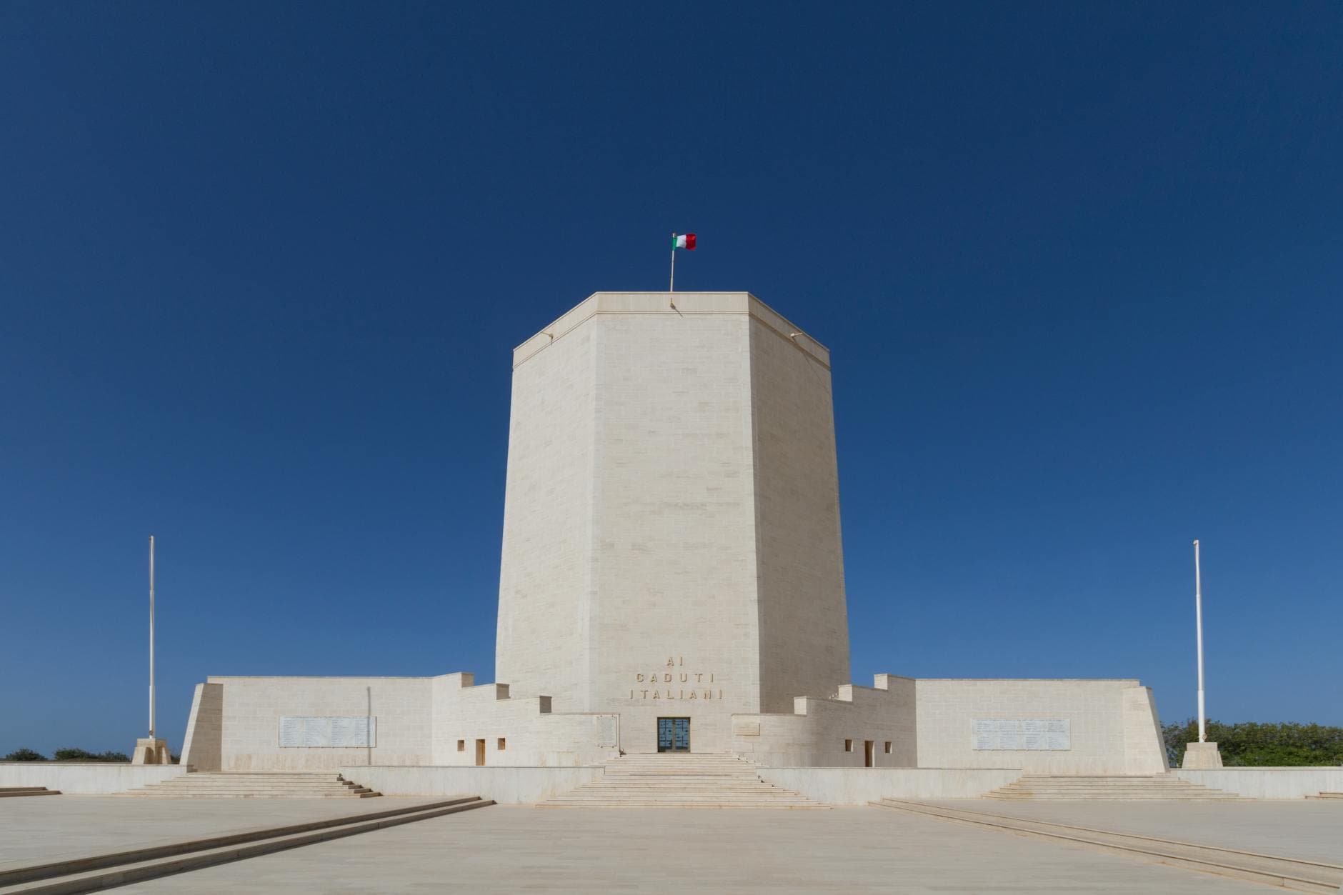 A majestic memorial tower in Italy with clear blue skies, symbolizing peace and remembrance.