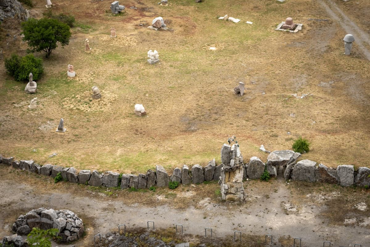 Ancient stone monuments scattered across a dry, grassy field.