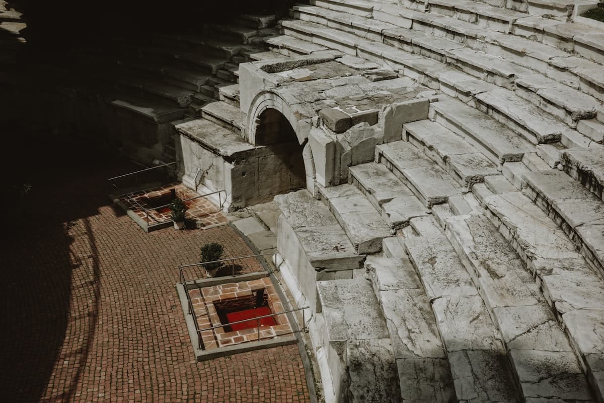 Ancient stone amphitheater seating with arched entrance