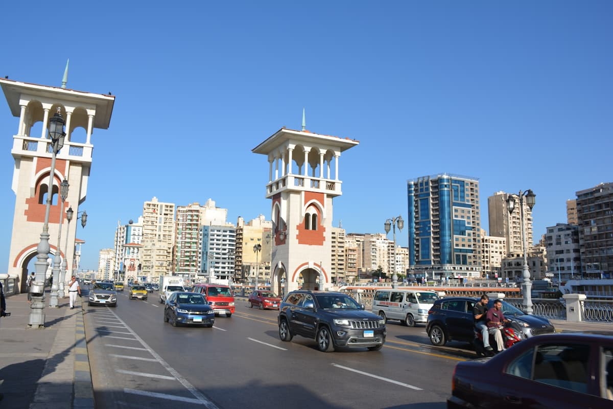 Traffic on a bridge with ornate towers and city skyline.