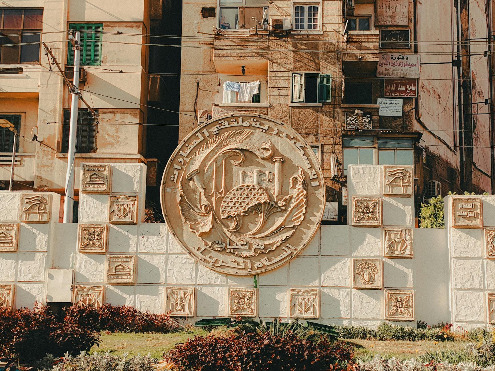 A detailed relief sculpture in an urban area, showcasing Middle Eastern architectural elements and cultural motifs.