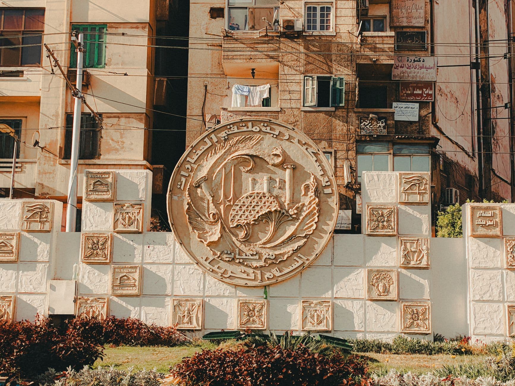 A detailed relief sculpture in an urban area, showcasing Middle Eastern architectural elements and cultural motifs.