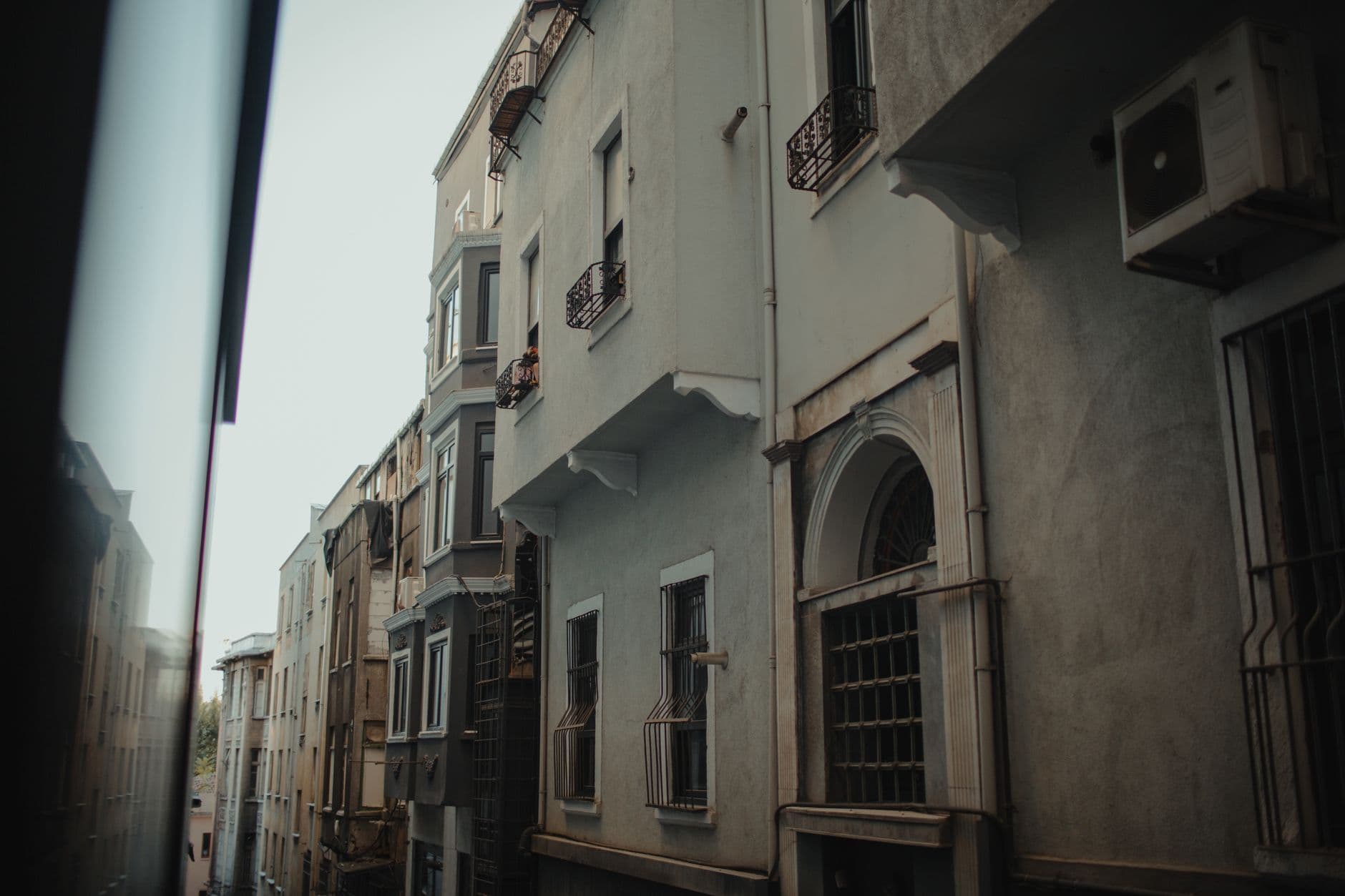A view of residential buildings along a narrow alleyway with intricate architectural details.