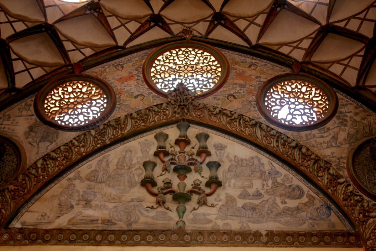 a decorative ceiling with three circular windows above it