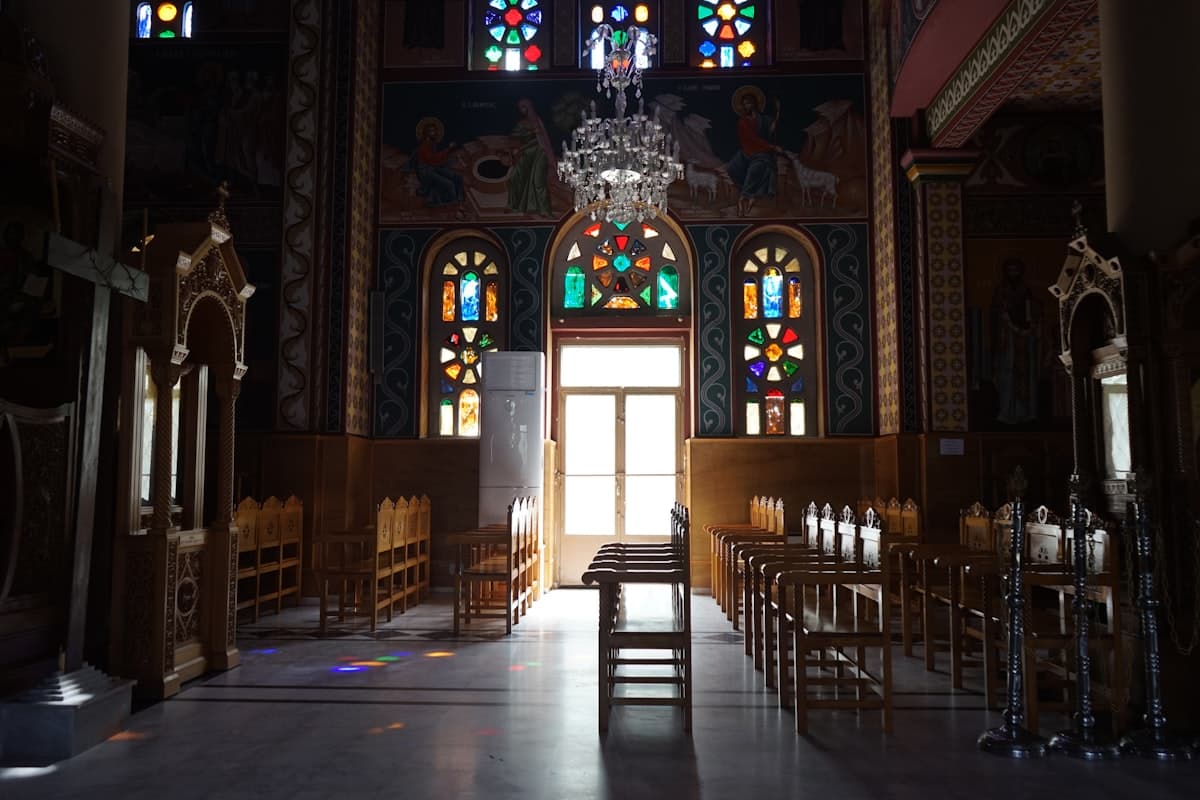 a church with a chandelier and stained glass windows