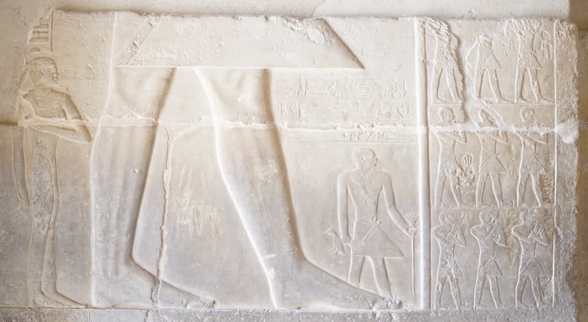 a white sculpture of a person standing in front of a wall