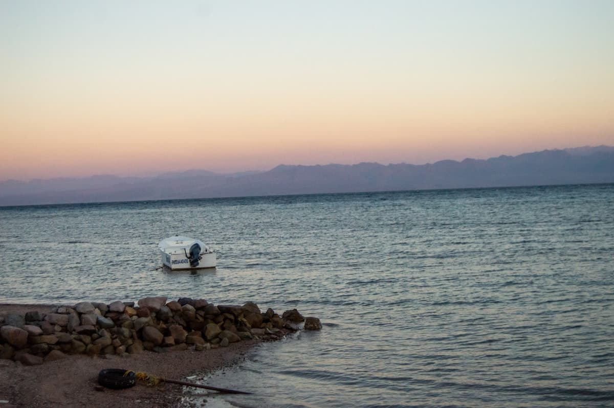 a small boat floating on top of a body of water