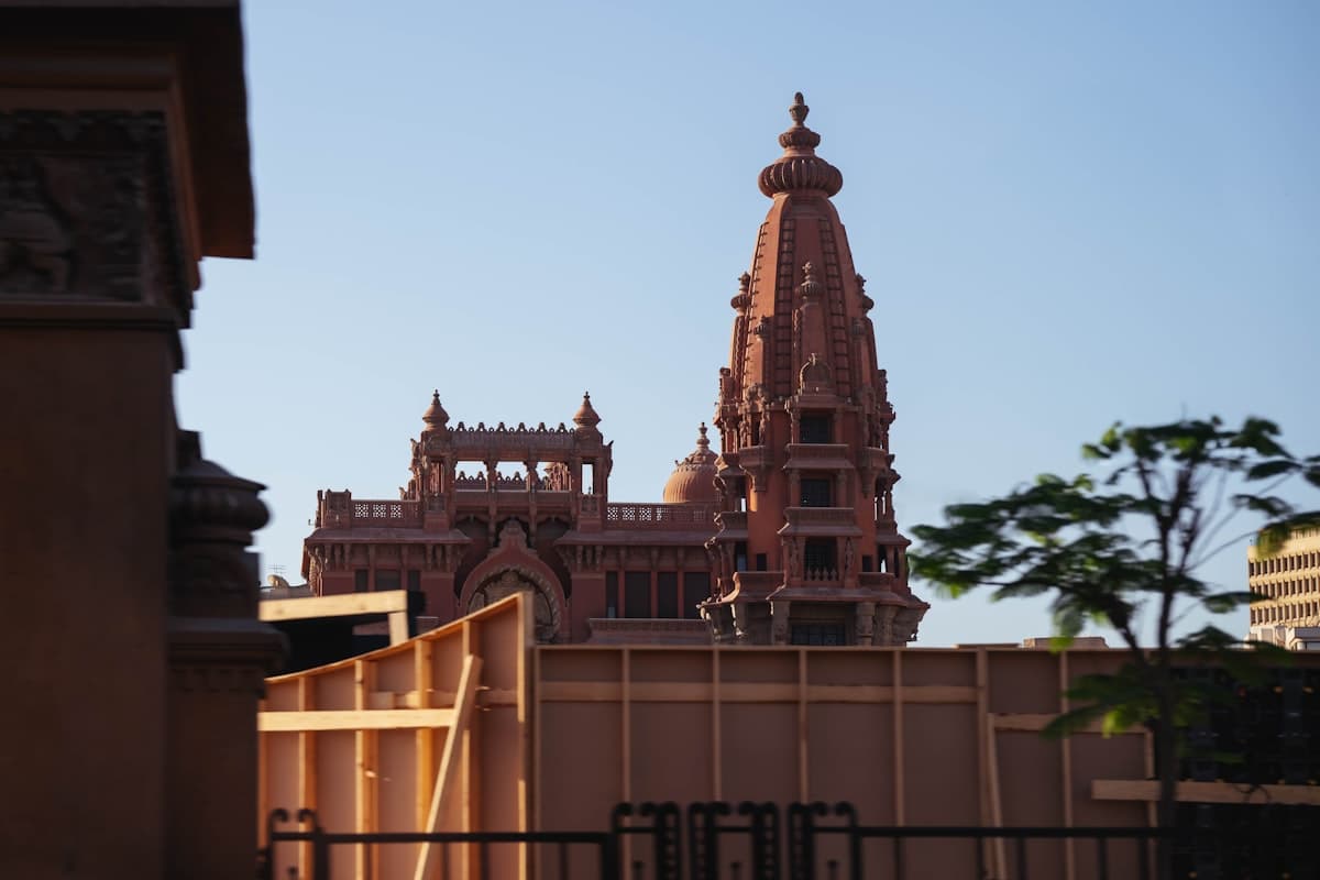 Ornate pink building with a tall spire under a clear sky