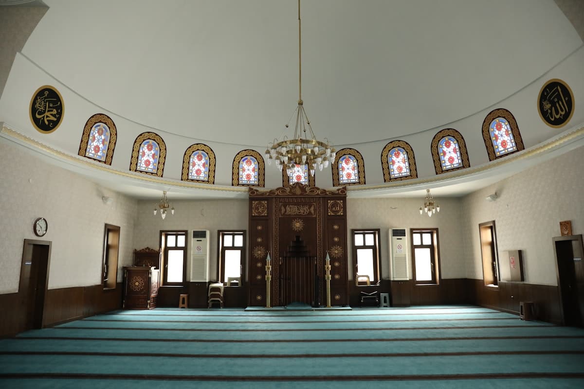 Interior of a mosque with prayer rugs and ornate decor