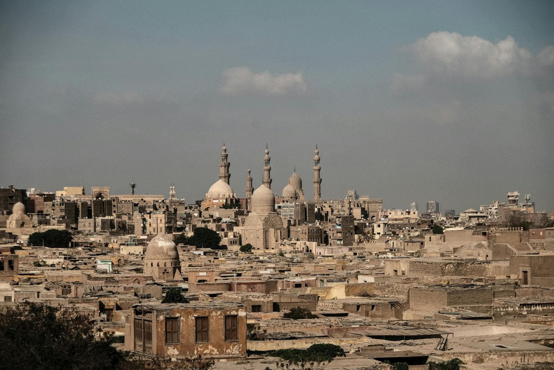 Panoramic view of Cairo's historic Islamic skyline with domed architecture and minarets.