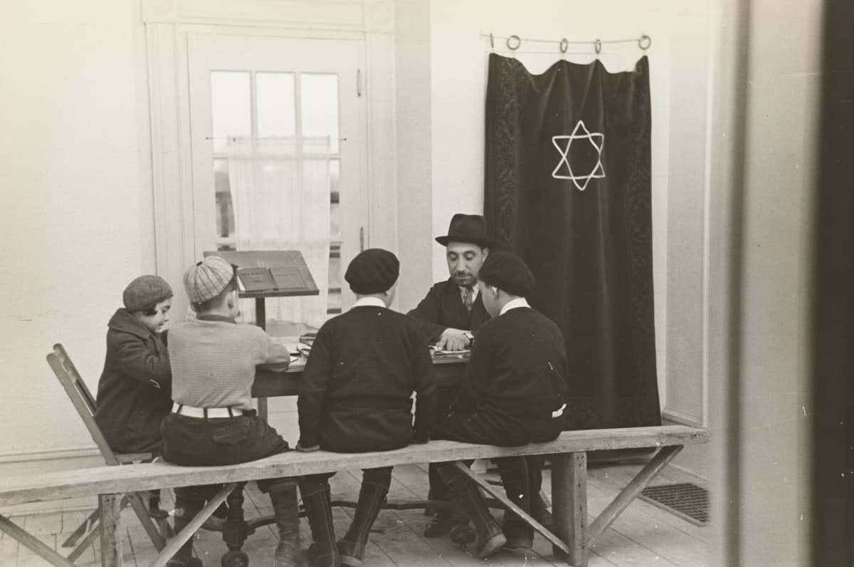 grayscale photography of five people sitting near table