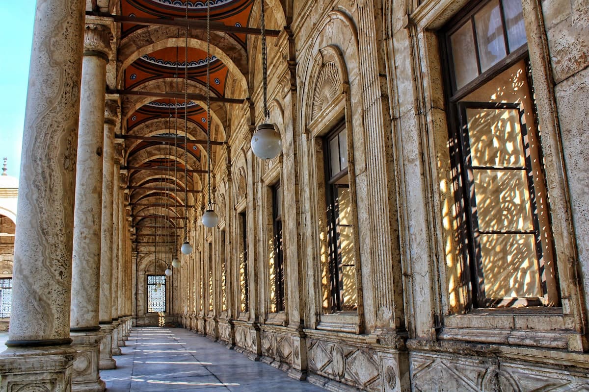 Arched colonnade with sunlight patterns on windows