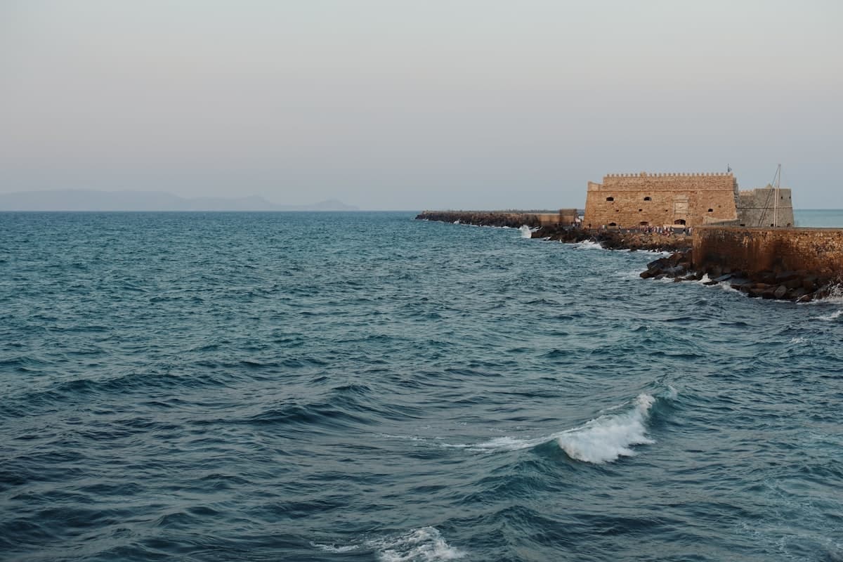 a large body of water next to a brick wall