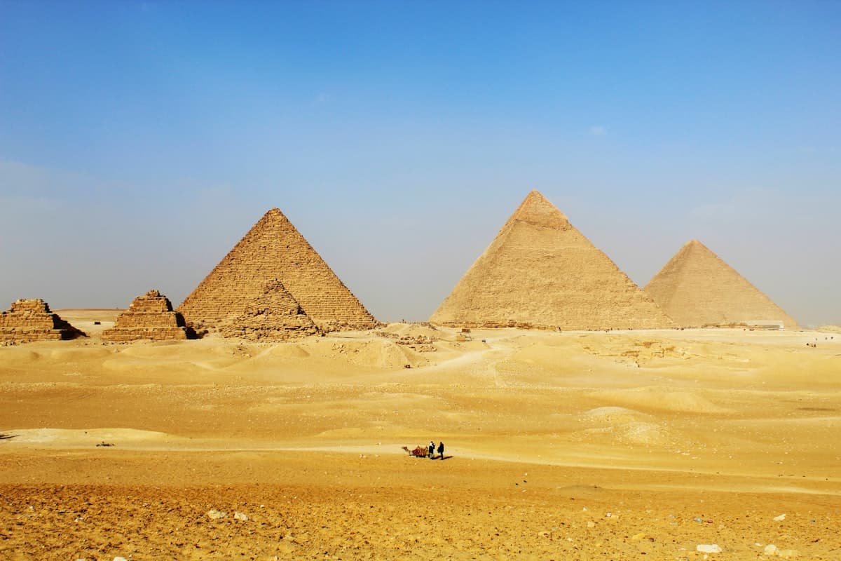 a group of pyramids in the desert with a sky background
