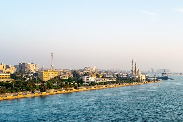 Suez Canal supertanker passing Ismailia waterfront aerial view