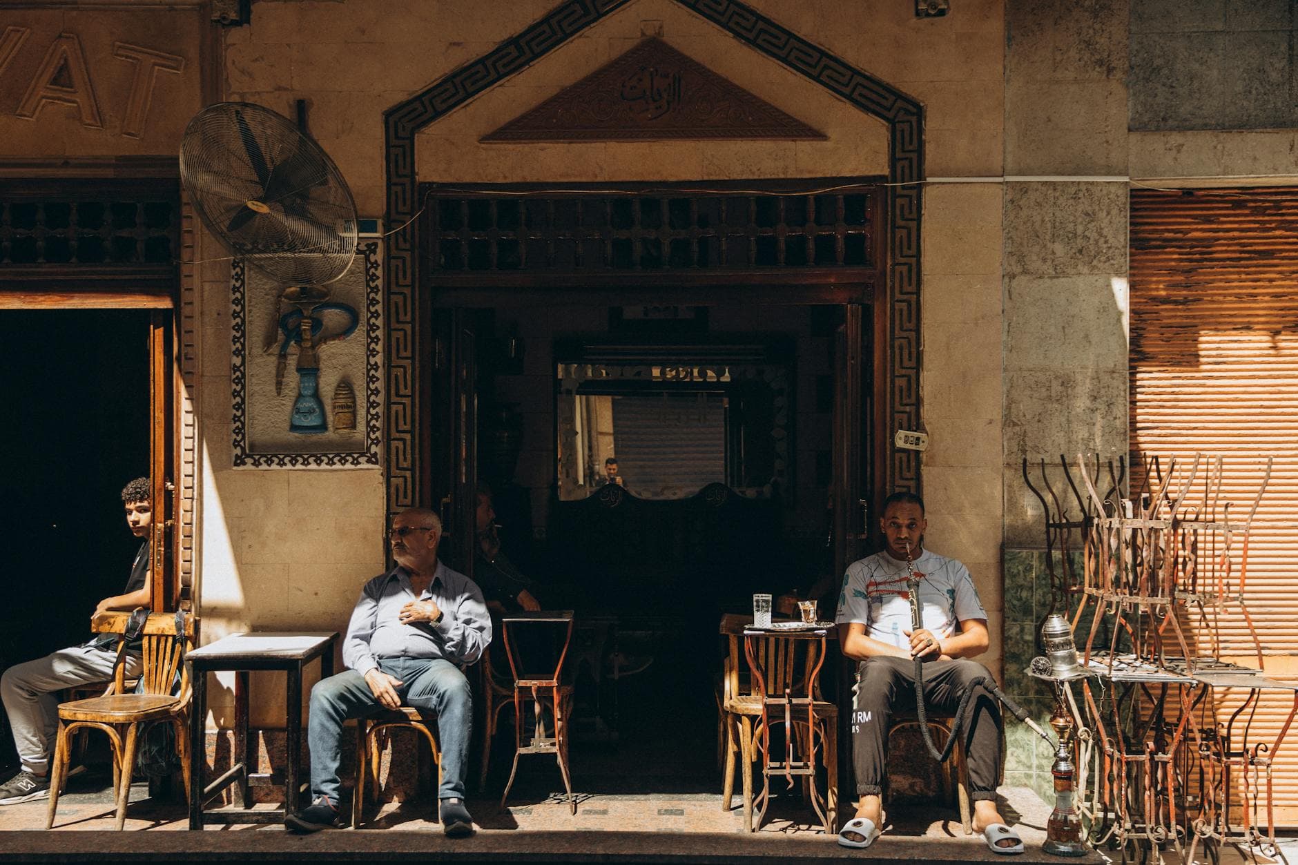 A vibrant scene at a traditional Cairo café featuring locals enjoying a sunny day.