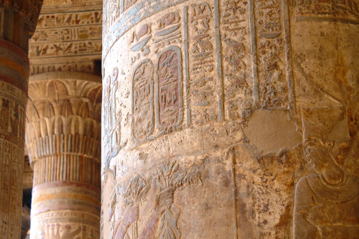 Intricate hieroglyphs carved into ancient egyptian temple columns.