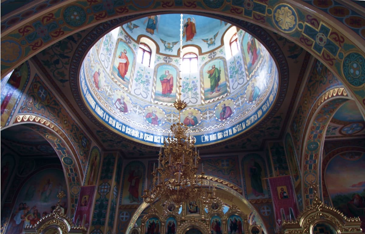 a large ornate ceiling with a gold statue and a gold cross