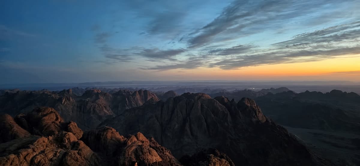 Mountains under a colorful sky at sunset.