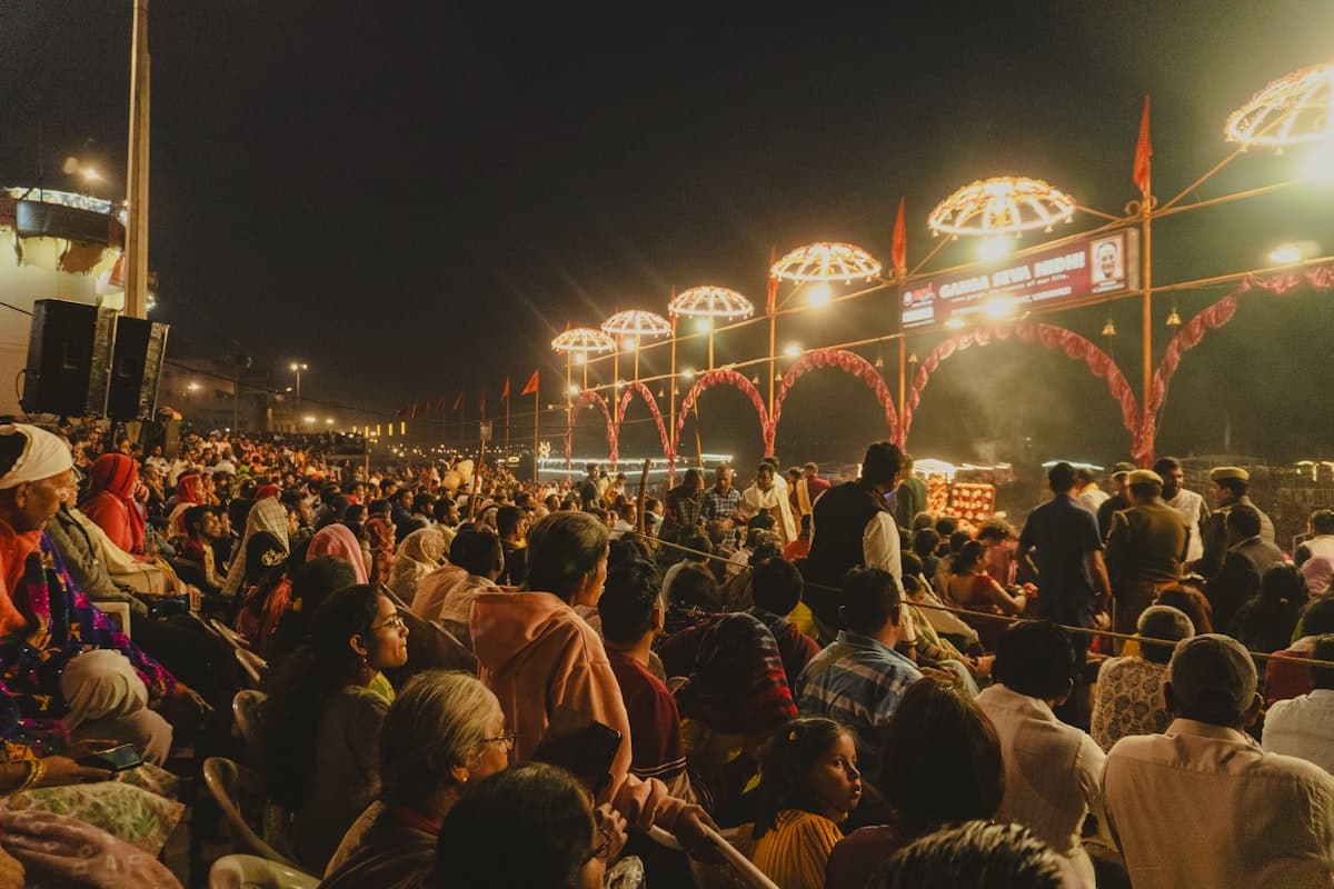 Crowd gathered at a brightly lit festival at night.