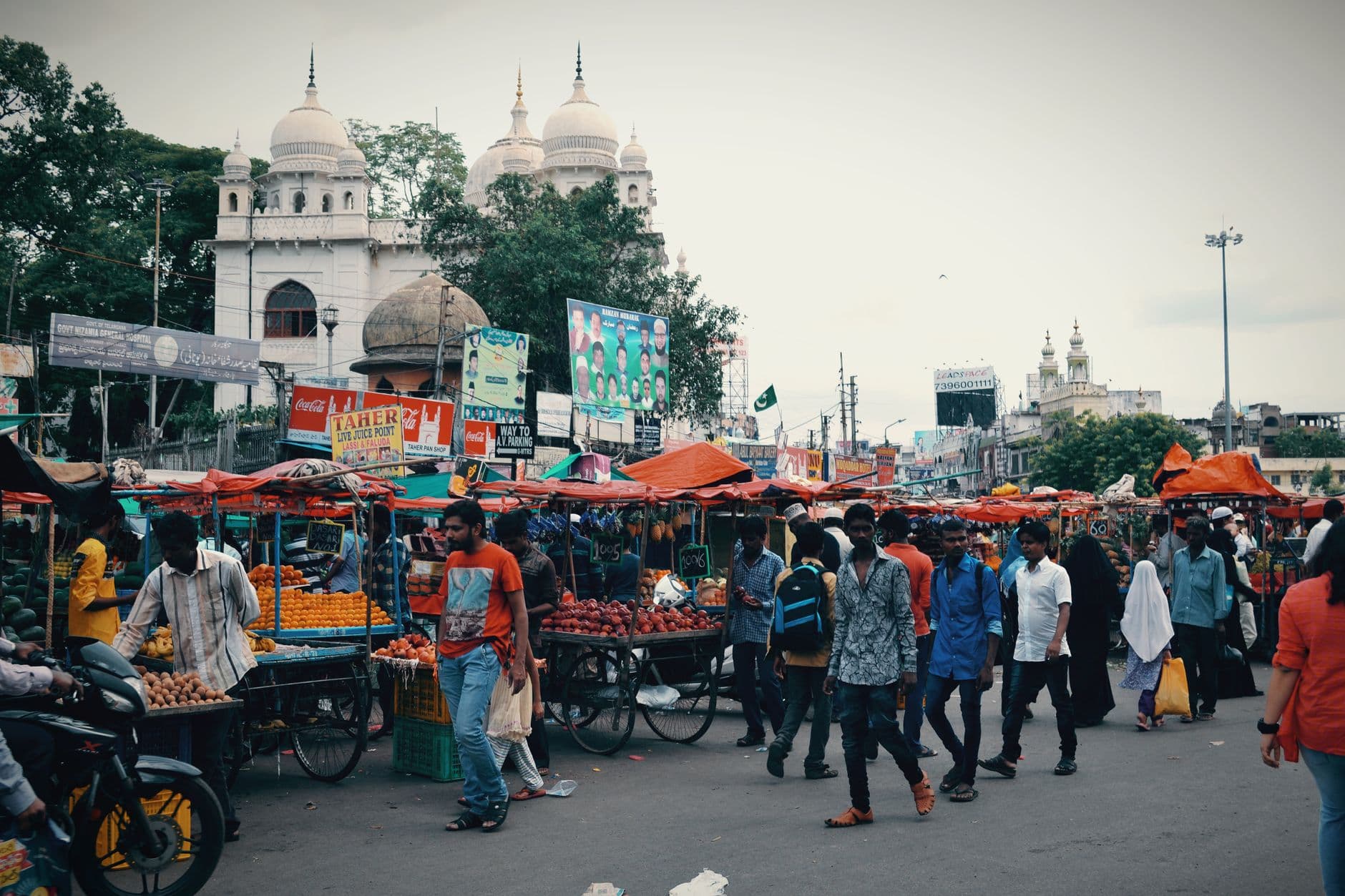 Bustling street market in India with people shopping and vendors selling fresh produce.
