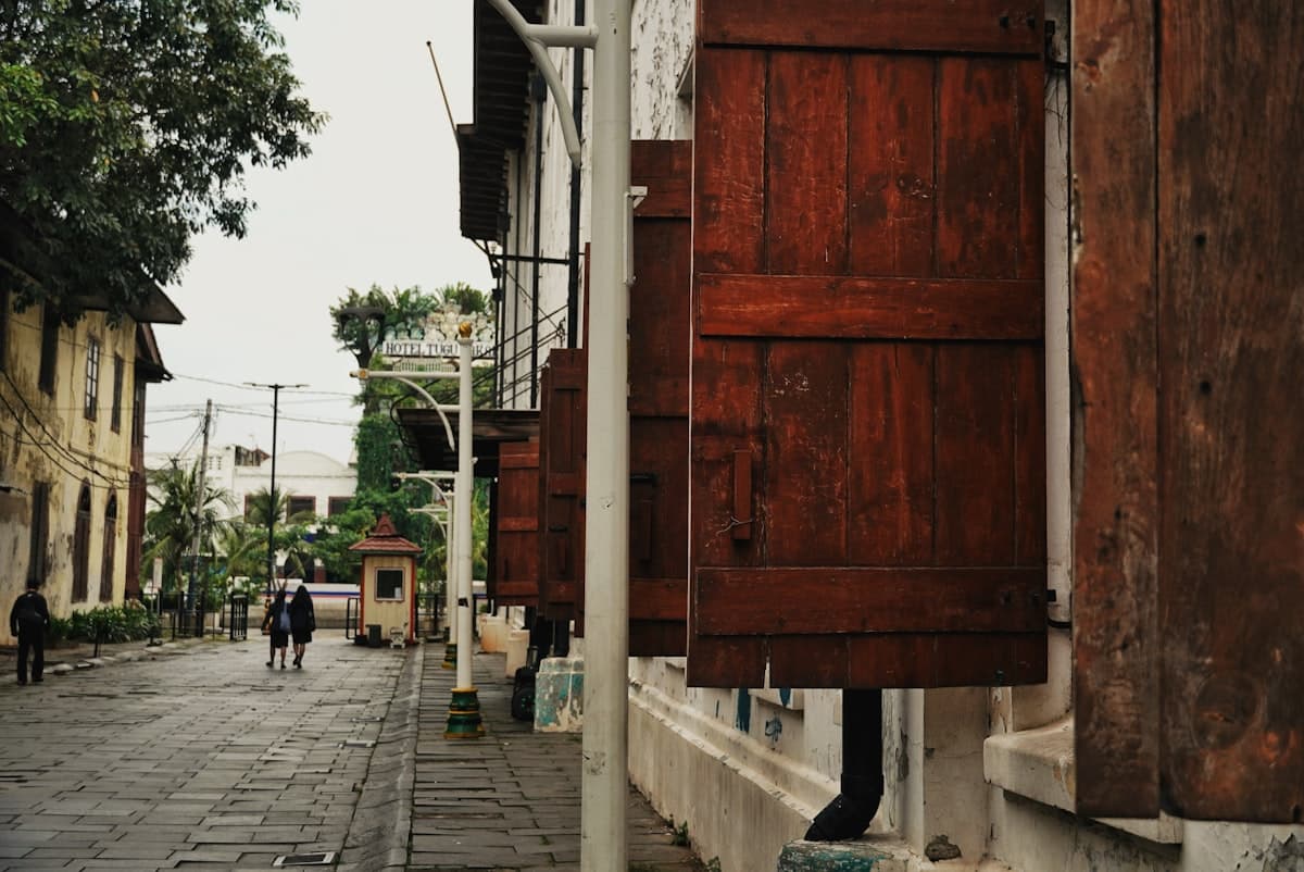 Old wooden shutters on a cobblestone street.