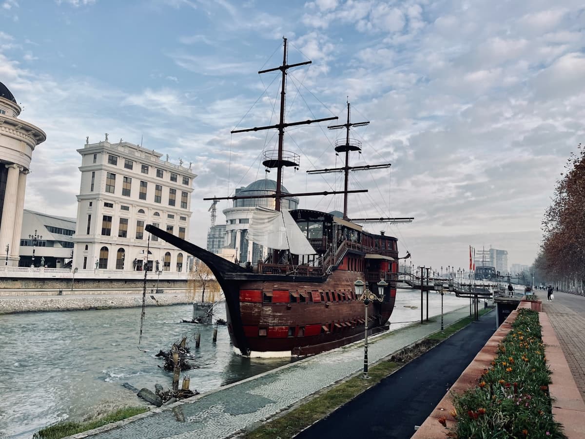 a large boat floating on top of a river next to tall buildings