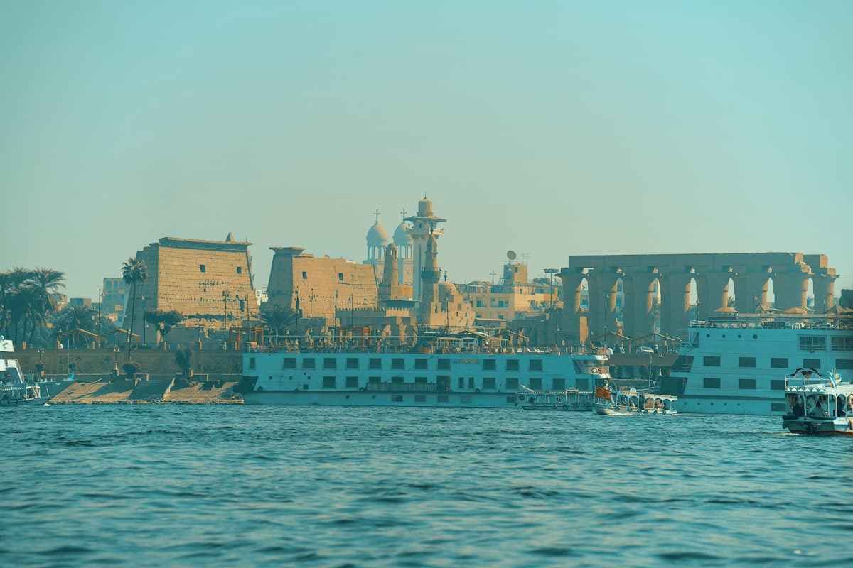 Ancient egyptian temples and boats on the nile river.