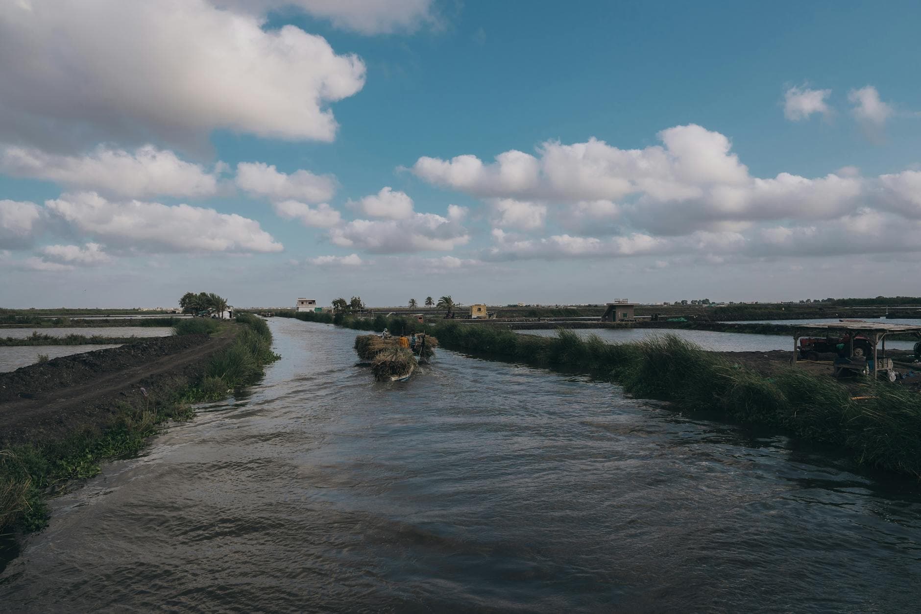 Picturesque view of a canal in Kafr El-Shaikh, Egypt with clear skies and farm landscapes.