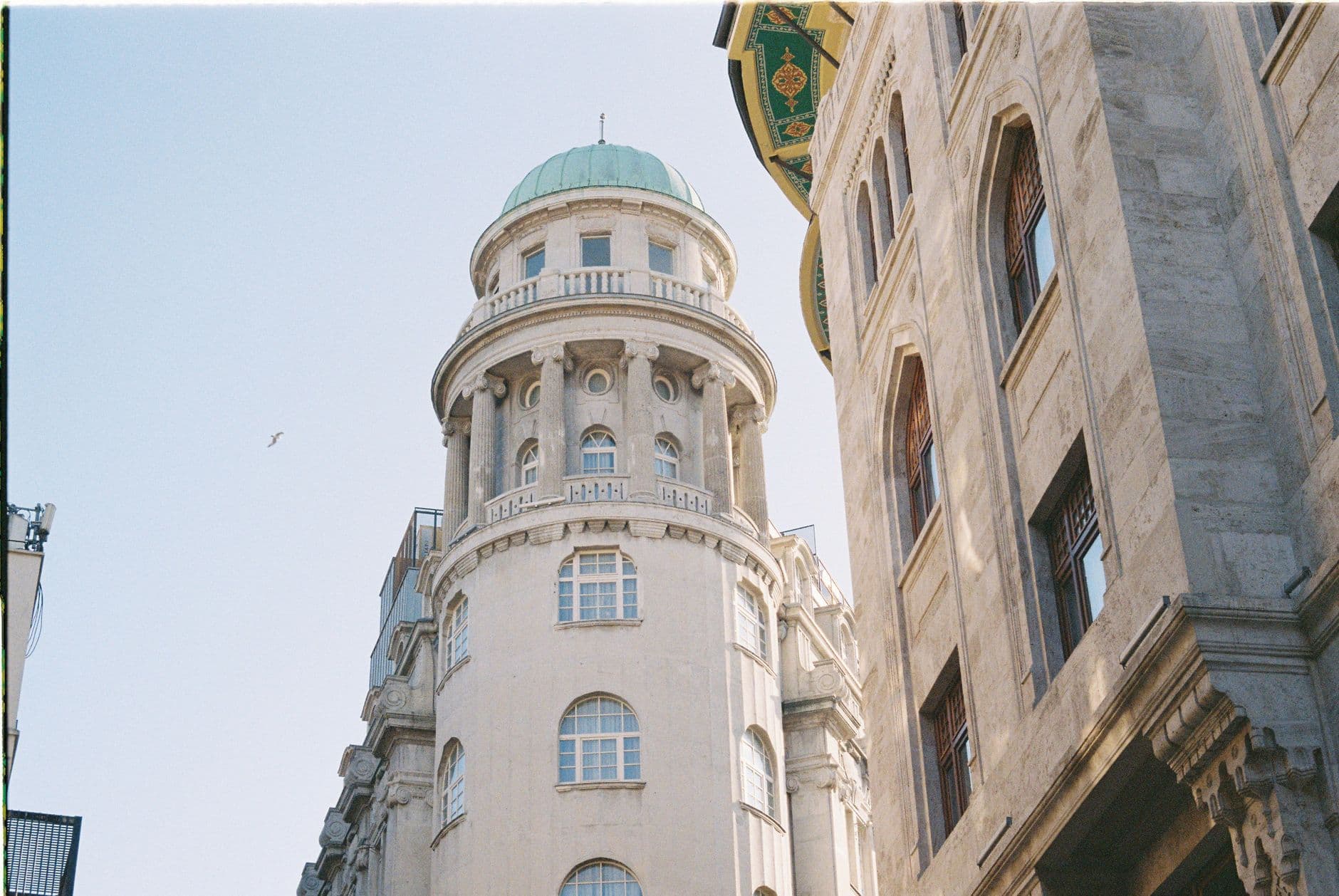 A classic building with a green dome under a clear blue sky, showcasing traditional architectural design.