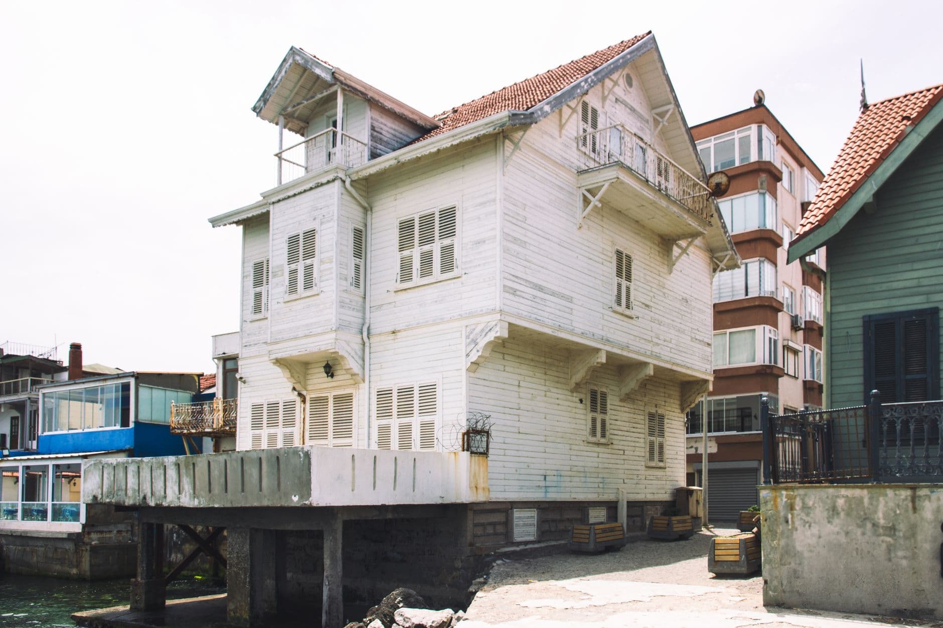 Historic white wooden house on the waterfront, showcasing traditional coastal architecture.