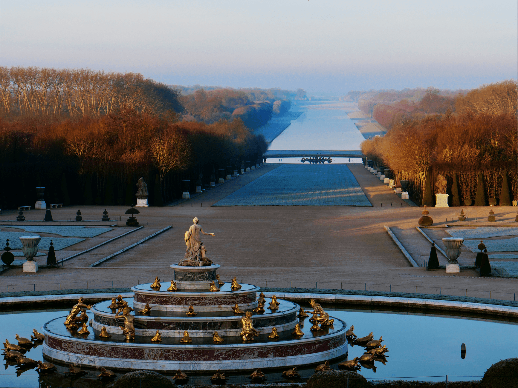 Stunning view of the Fountain of Apollo in the Versailles Gardens with autumn foliage.