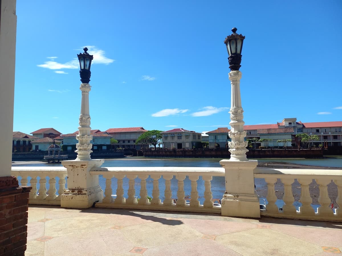 Two ornate lampposts stand by a waterfront promenade.