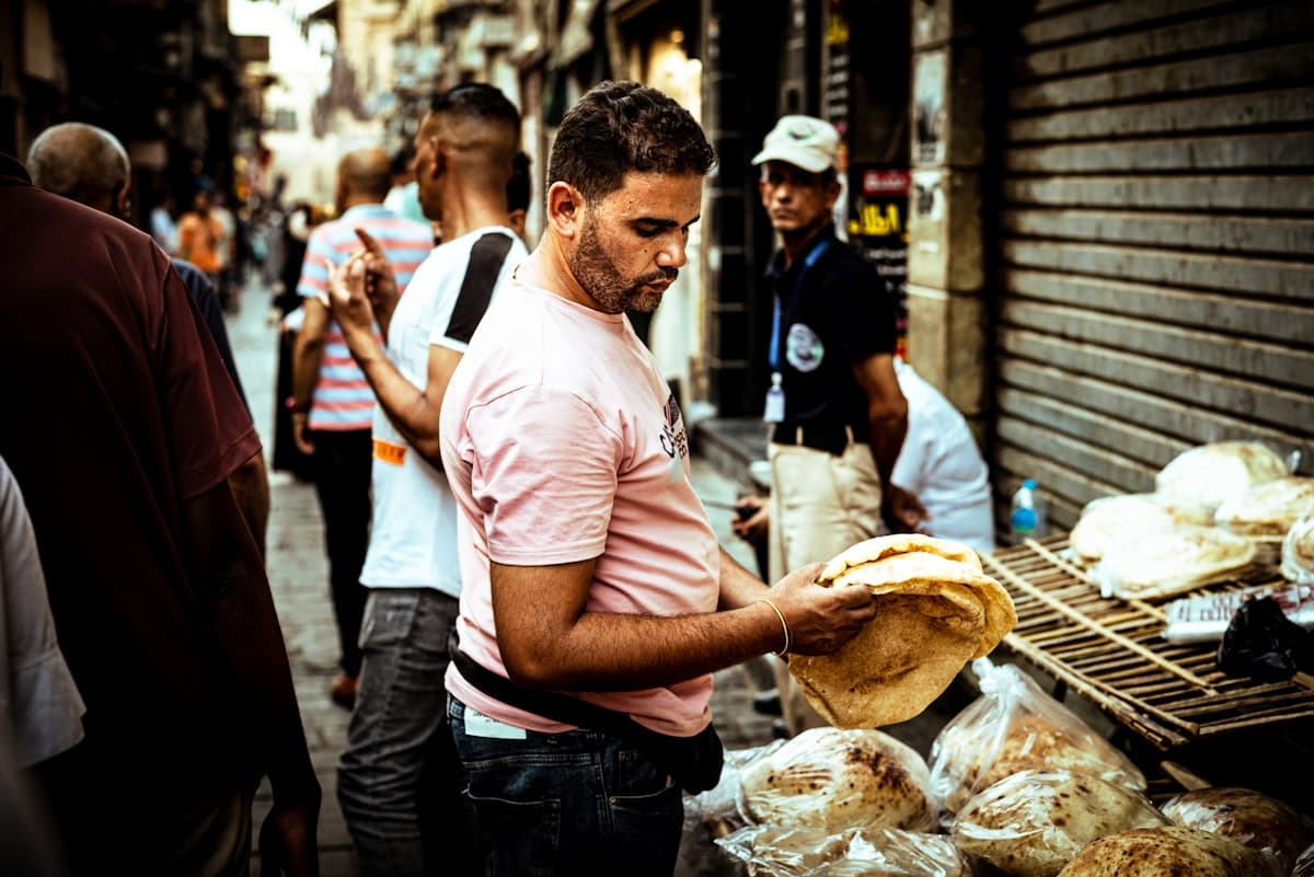 A man standing in front of a bunch of bread