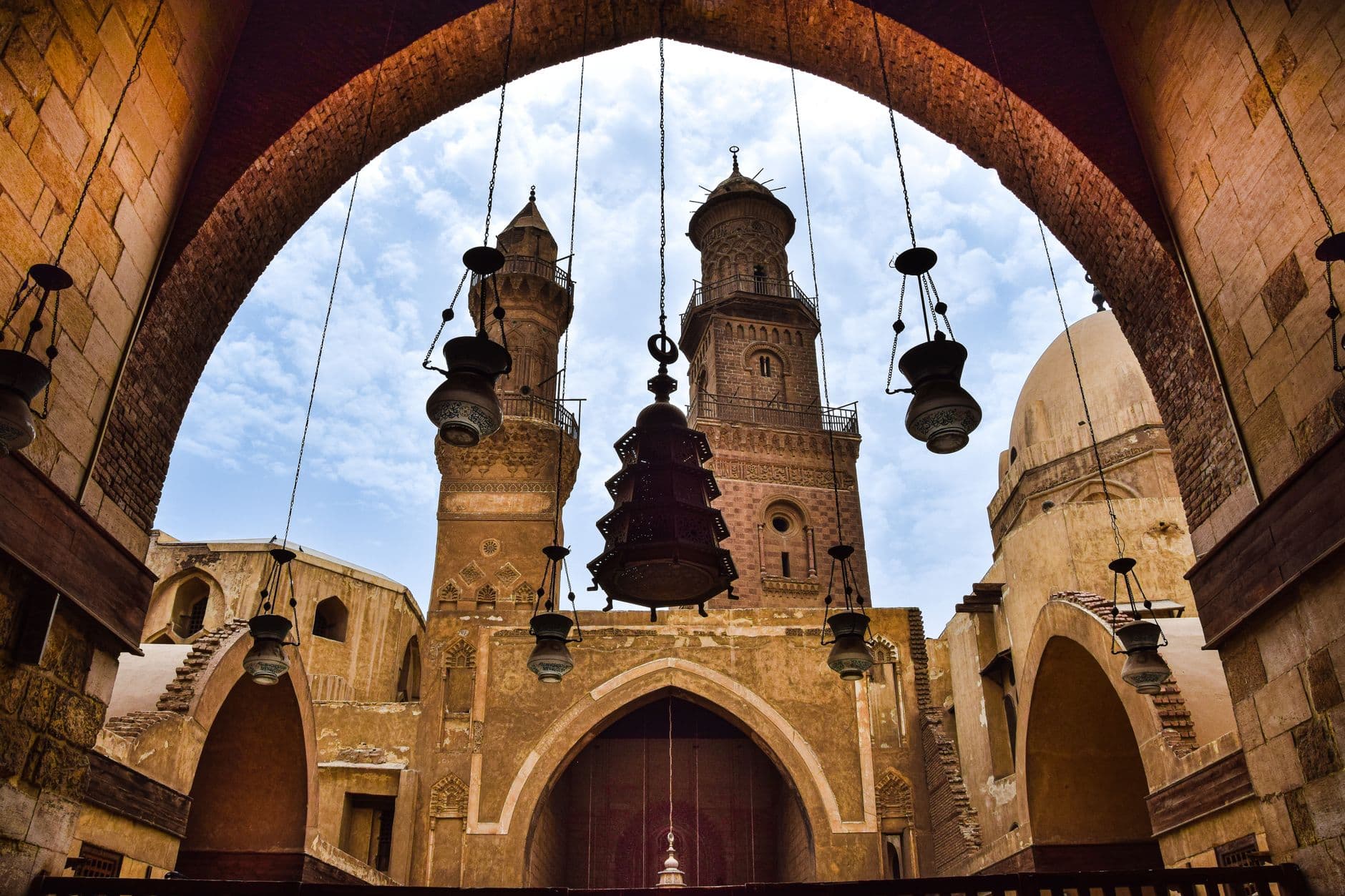 Majestic Islamic architecture with arches and towers at Qalawun Complex, Cairo.