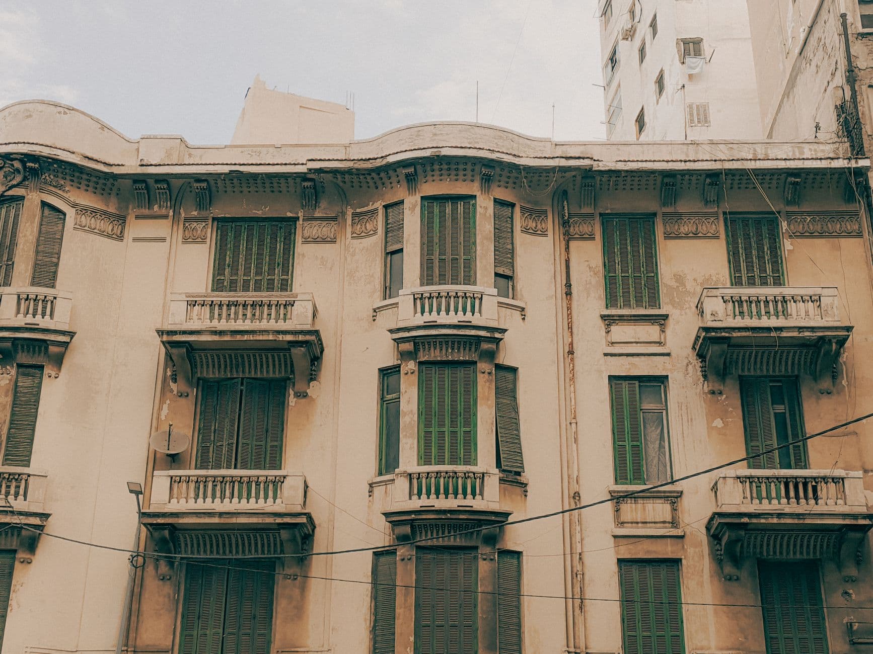Vintage architecture with distinctive green shutters on an old building facade.